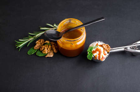 Three colorful balls of delicious ice cream, on a black background with nuts and a sprig of mint. Copy spaceの写真素材