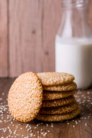 Round sesame cookies with milk and juice on the table. Sesame seeds for bakingの写真素材