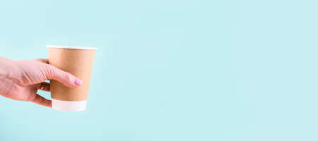 Paper glass in the hand . Eco utensils on a light background. Zero waste.の写真素材