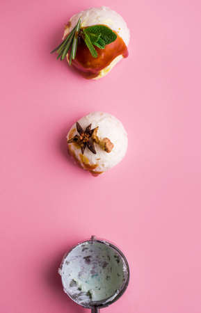 Colorful delicious ice cream on a pink background, with spices, mint leaves. A place to textの写真素材