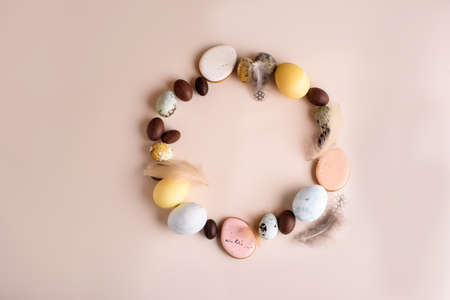 Beautiful Easter composition of eggs with natural colors, gingerbread, flowers, feathers. Holiday content.の写真素材