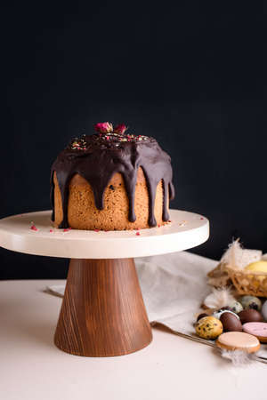 Easter cake on a beautiful stand with chocolate glaze Confectioner decorates the cake with glaze.