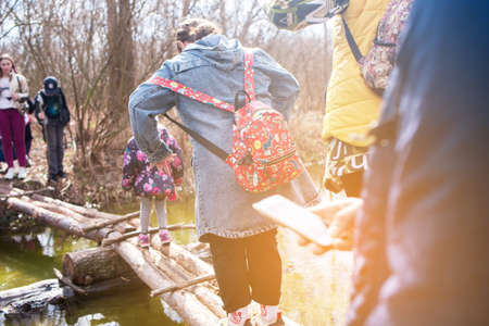 Children's hike in the woods. Children cross the wooden bridgeの写真素材