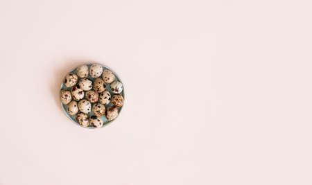Overquail eggs with young sprigs of green plants on a light background. Holiday content, a place for...
