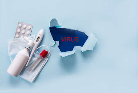 Torn paper with the word virus, medicines for treatment, face mask, tablets, guard. Quarantineの写真素材