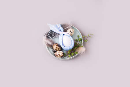 Overquail eggs with young sprigs of green plants on a light background. Holiday content, a place for...