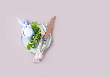 Overquail eggs with young sprigs of green plants on a light background. Holiday content, a place for...