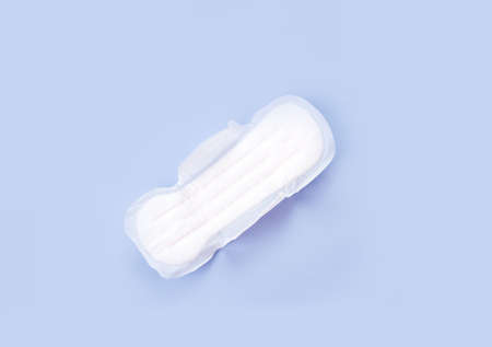 Sanitary pad on pink, cotton flowers. Personal care, woman hygiene concept. Critical days, blood...