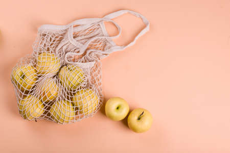 Ripe apples of different varieties in an eco bag on a light background. View from above. Eco shopping.の写真素材