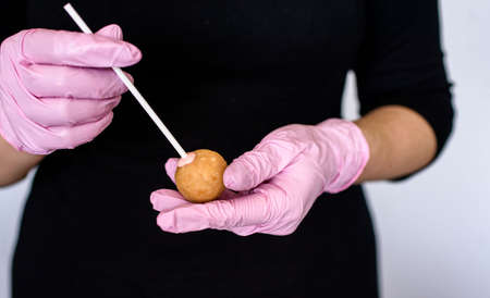 The process of creating dessert with the hands of a pastry chef. Cream, cake, sugar. Cake pops.の写真素材