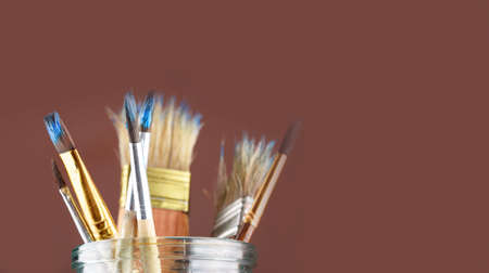 Brushes for drawing paints of different sizes stand in a jar on a monochrome background. Creativity, a place for text.の写真素材