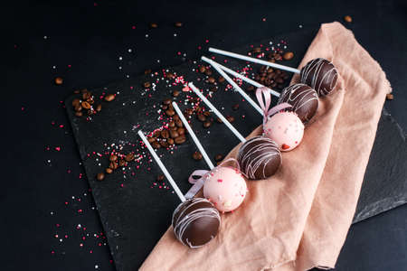 A beautiful composition of dessert on a stick with different cream. Tasty cake pops
