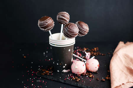A beautiful composition of dessert on a stick with different cream. Tasty cake pops