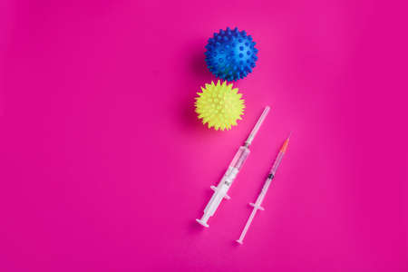 The hand in the gloves holds a syringe and injects the virus. Content for coronavirus on a pink...