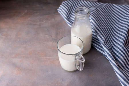 Fresh milk in a glass cup and a bottle with a beautiful towel on the table. Fresh drinkの写真素材
