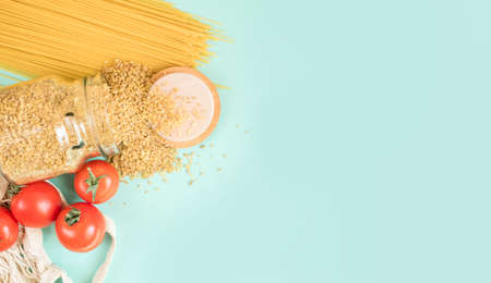Fresh produce on a light background. Spaghetti, tomato, bulgur, stew, pepper, eco bag. View from above, place for text.の写真素材