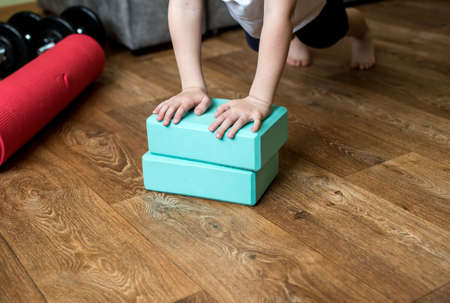 The boy plays sports with gymnastic blocks. Exercise during quarantine.の写真素材