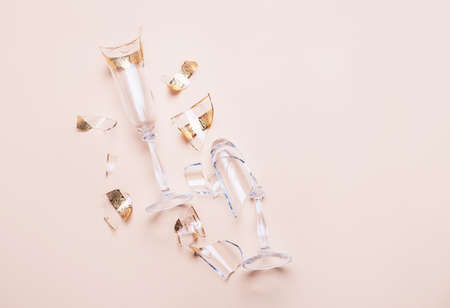 Two broken glass glasses lie on a colored background with tattical shadows. View from above, place for inscription.の写真素材