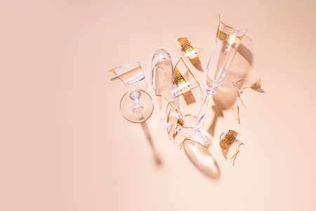 Two broken glass glasses lie on a colored background with tattical shadows. View from above, place for inscription.の写真素材