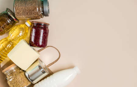 Craft package with grocery purchases. Toilet paper, cereals, a taus, on a light background. View...