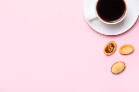 Homemade Russian nuts with condensed milk on a light pink background, wafer napkin. Cut nuts with...