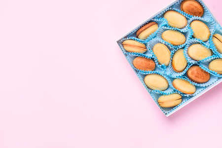Homemade Russian nuts with condensed milk on a light pink background, wafer napkin. Cut nuts with...