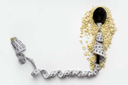 The spoon lies on top of dry oatmeal, and is wrapped in an inch. Healthy breakfast, diet, proper nutritio. Place for textの写真素材