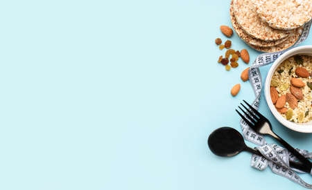 Useful breakfast, proper nutrition, oatmeal, dried fruits, breads, fruits, a centimeter on a light background. Diet. A place for text. Flat layの写真素材