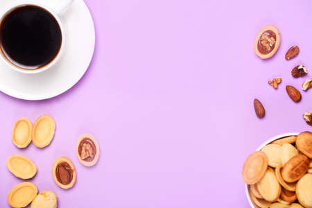 Homemade Russian nuts with condensed milk on a light pink background, wafer napkin. Cut nuts with...