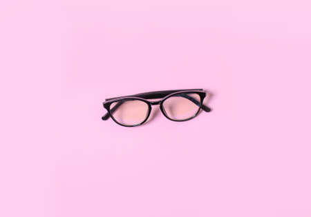 Computer glasses lie in the center on a pink background.の写真素材