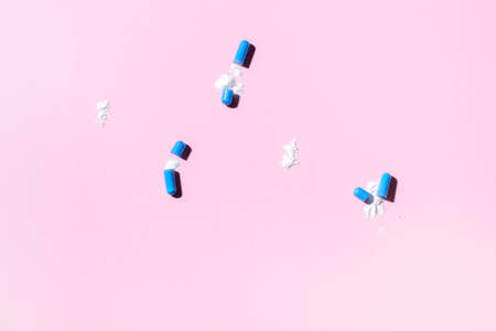 Blue pills an pill bottle on pink background. Pattern. Place for textの写真素材