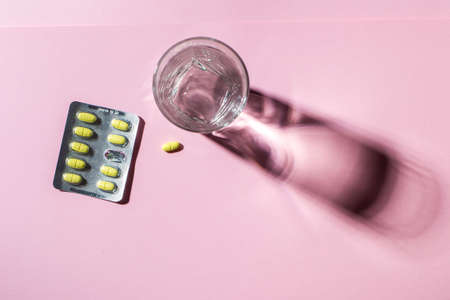 A glass of clean water with natural vitamins, with shadows on a light background. View from above. Healthcareの写真素材