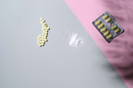 Different medicines lie on a colored background, a shadow from the leaves. Place for text, top viewの写真素材