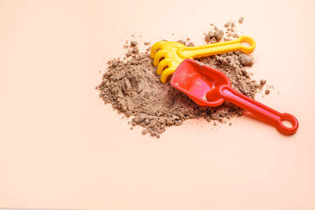 Beach sand with toys for the baby, water, the word summer in colored letters. Staycation content