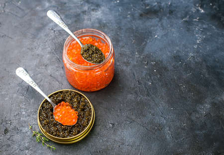 Fresh red and black caviar, seafood, dark background, top view. Good food. Delicious food content