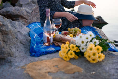 A girl with flowers by the sea at dawn at a picnic. Romantic morning.Summer - Girl with a basket