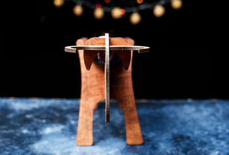 A wooden stand for a bottle of wine, in the form of a symbol of the new year, in the form of a bull. New Years lights,の写真素材