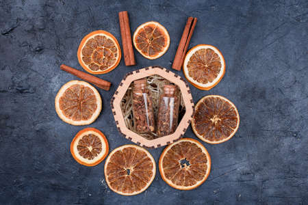 Slices of dried orange, cinnamon sticks, jars of spices for mulled wine. Winter drink