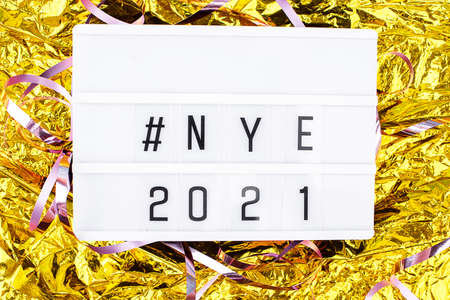 Light boxing with the words nye 2021 on a golden background. New Years Eve and content.