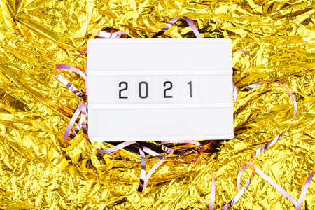 Light boxing with the words 2021 on a golden background. New Years Eve and content.