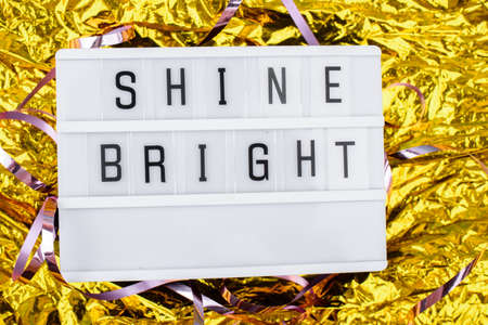Light boxing with words shine bright on a golden background. New Years contentの写真素材