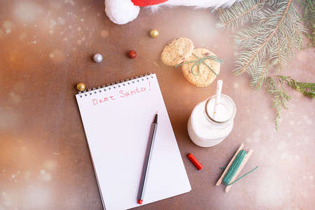 Delicious cookies with chocolate on a white plate, milk, santa hat, muck up for text. Letter and cookies for Santa.の写真素材