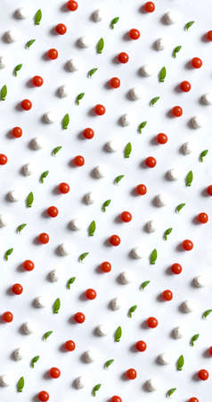 Caprese salad ingredients in rows. Top view of tomatoes, mozzarella cheese and fresh green leaves. Food photobomb perfect patternの写真素材