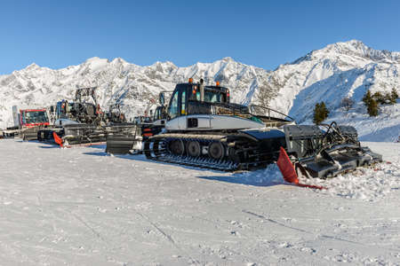 Ratrack machines for skiing slope preparations in French Alps. Mountains on the background. Sunny day with blue sky.の写真素材