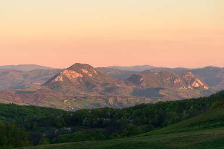 Apennines mountain landscape seen from the "Bone Plain" at sunrise time in the morning, in a wide valley near Firenzuola, on the path of the Gods road or "the way of the Gods"の写真素材
