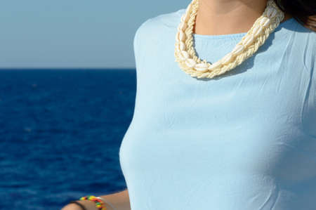 Young girl on boat against the blue sea with a blue dressの写真素材