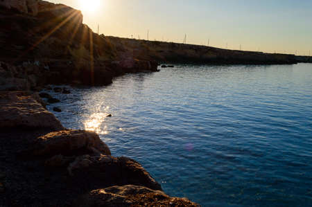 Cristal clear water and no people at the famous Cala Azzurra in Favignana, Italy. A perfect calm sunrise in this paradise island in the mediterranean seaの写真素材