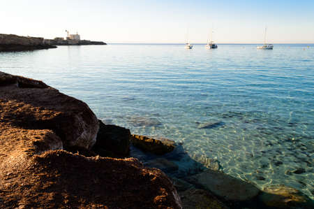 Cristal clear water and no people at the famous Cala Azzurra in Favignana, Italy. A perfect calm sunrise in this paradise island in the mediterranean seaの写真素材