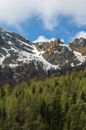 Mountains peaks back lit at sunset time in Valle D'Aosta in Northern Italy on a trekking trail...