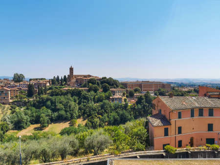 Cityscape of the old town of Siena a wonderful place in Tuscany, Italy with its old medieval little building and red roofs seen from Orto dei Tolomeiの写真素材